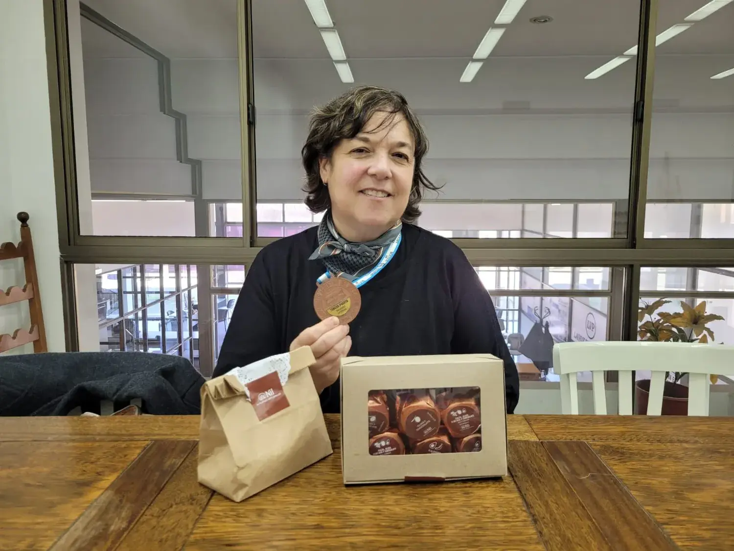 Nilda Irigoin con la medalla y productos de Nil Alfajores