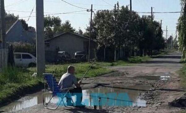 La Plata: A modo de protesta, un vecino se puso a pescar en un pozo de la calle