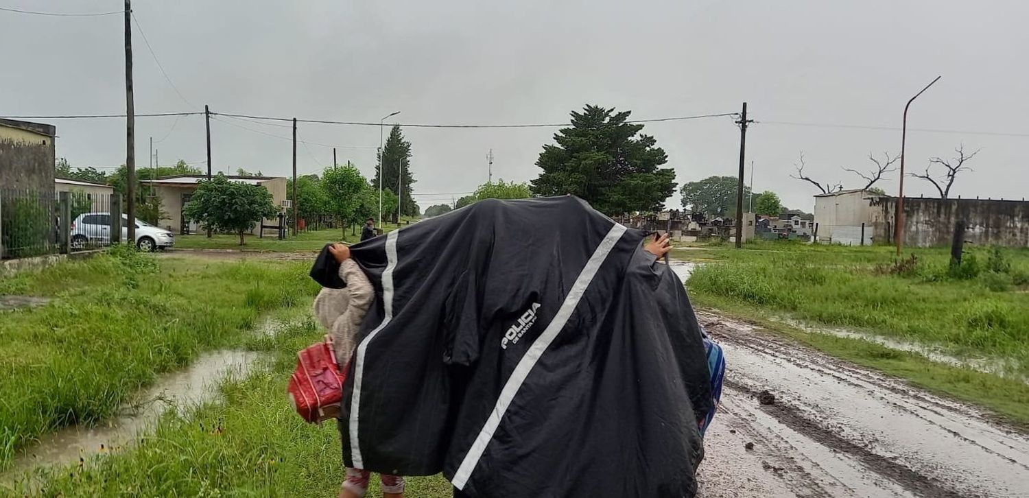 Una mujer policía cubrió con su capa a integrantes de uan familia evacuada en Tartagal.