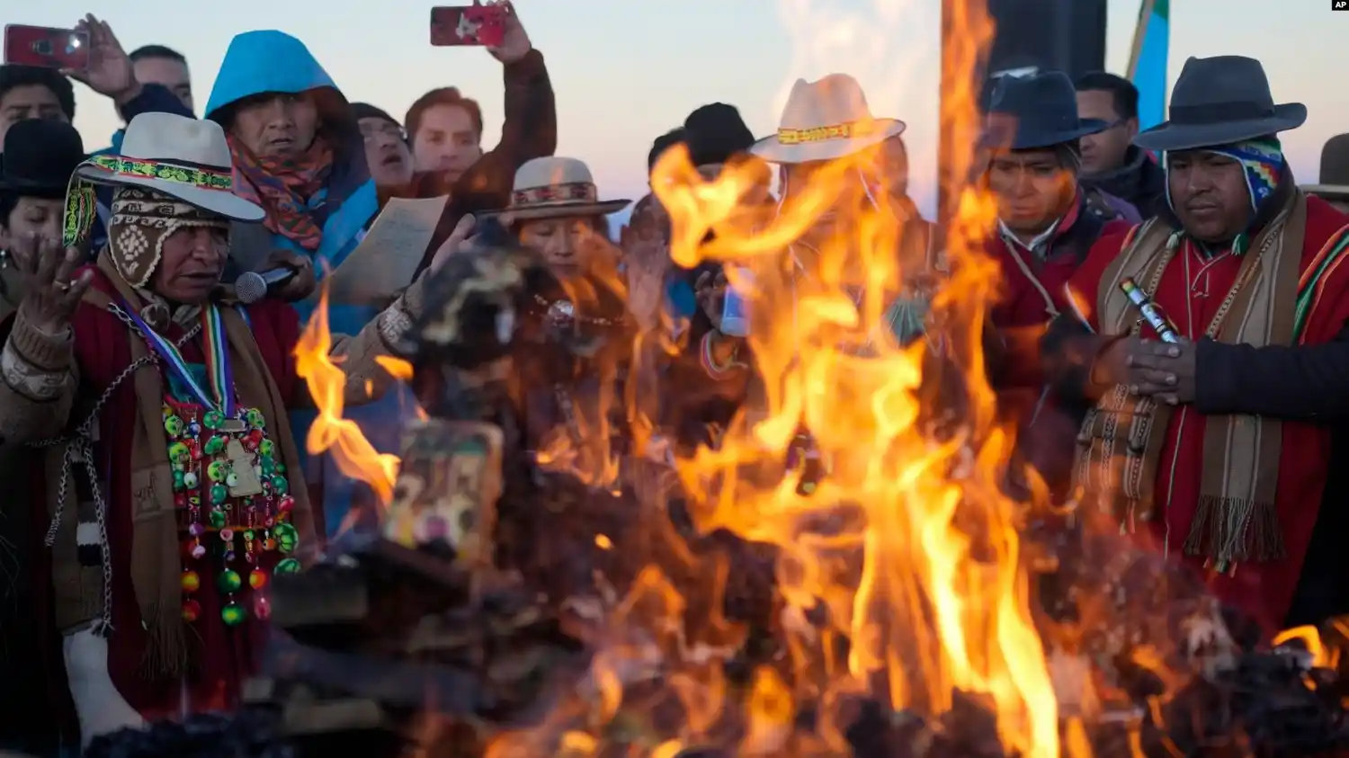 Indígenas aymaras queman ofrendas en honor a la Pachamama o Madre Tierra, después de recibir los primeros rayos de sol en un ritual de Año Nuevo en la montaña sagrada Apacheta Murmutani en las afueras de Hampaturi, Bolivia