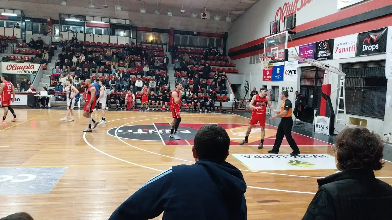 Un tenso pasaje del tercer cuarto, con Olimpia intentando achicar distancias y reclamos de Bautista Bazzetti a uno de los árbitros, ante la mirada de Chervo. Foto: Sur24