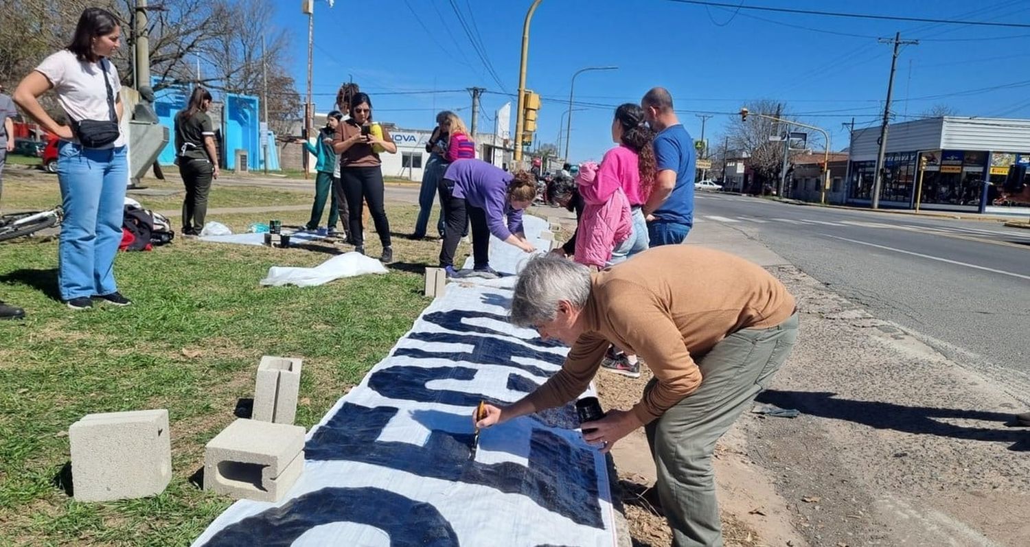 El decano de la facultad pintando el pasacalle.