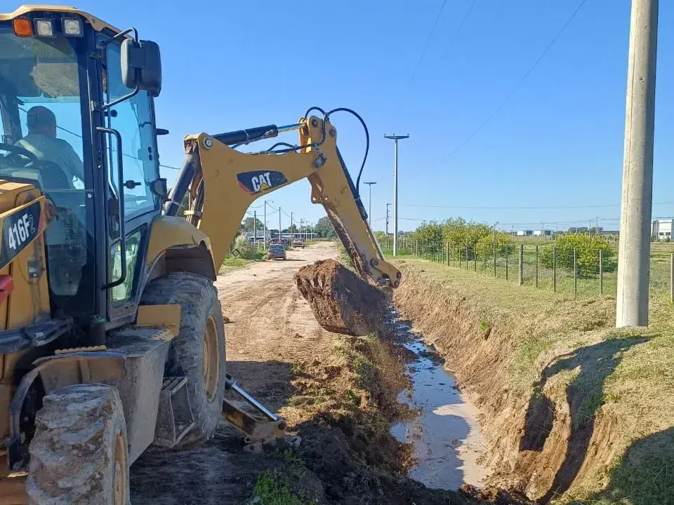 Una máquina municipal limpiando un desagüe en calle 47