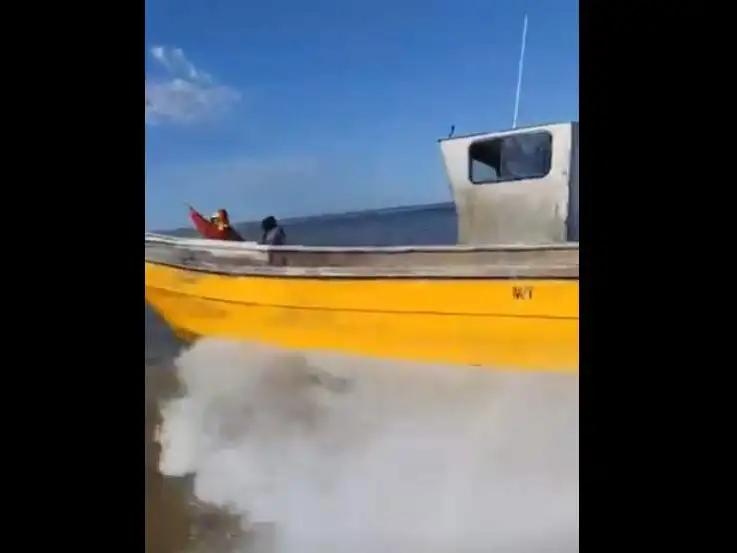 Una embarcación de la Armada se acerca a una de las barcas, que hacen caso omiso al llamado a detenerse.