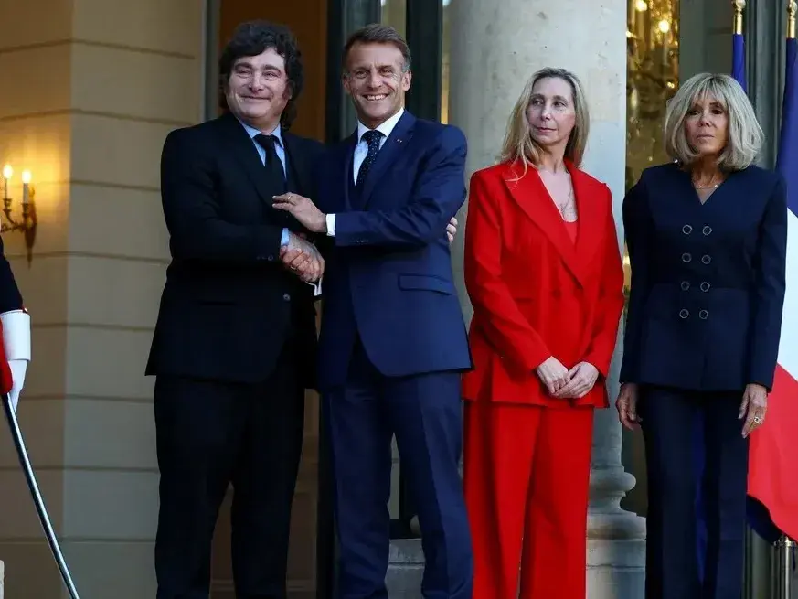 El presidente francés Emmanuel Macron y su esposa Brigitte Macron dan la bienvenida al presidente argentino Javier Milei y a su hermana Karina Milei, a su llegada al Palacio del Elíseo en París.