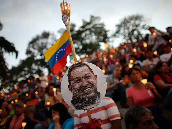Una multitud acompaña el cortejo con los restos de Chávez