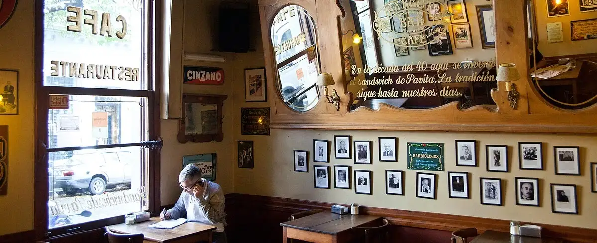 Mesas, retratos y leyendas: el interior del Café Margot mantiene viva la memoria barrial de Boedo y su tradición de cafés como espacios de lectura, escritura y pensamiento.
