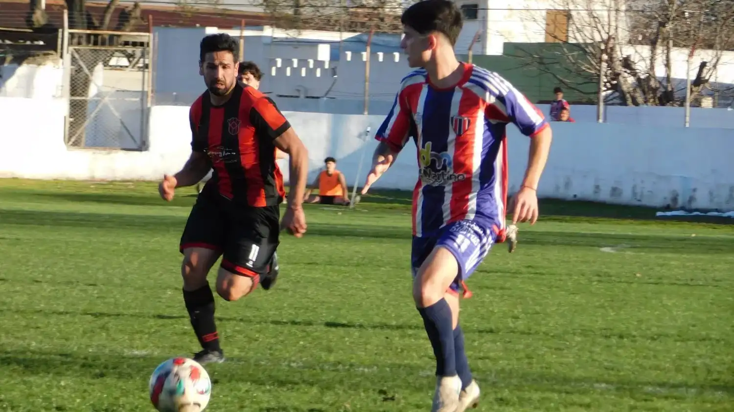 Leguizamón avanza, con Riganti persiguiéndolo.