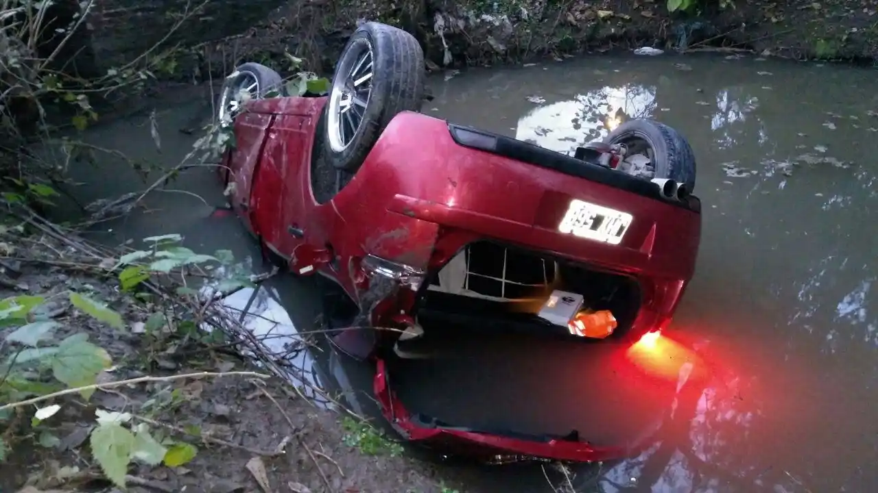Policía volcó su auto y terminó en un cañadón de agua