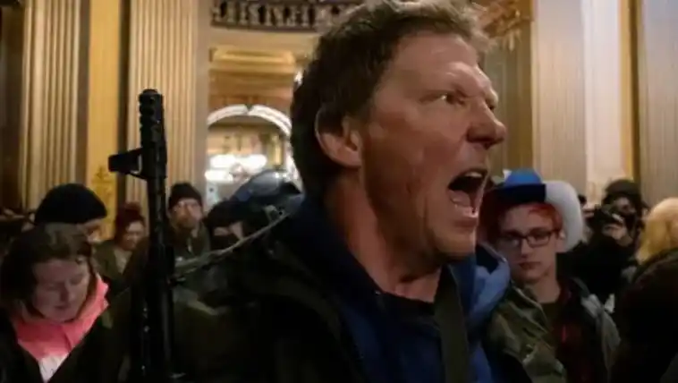 Un manifestante grita a la policía estatal de Michigan después de que los manifestantes ocuparon el edificio del capitolio estatal (REUTERS/Seth Herald)