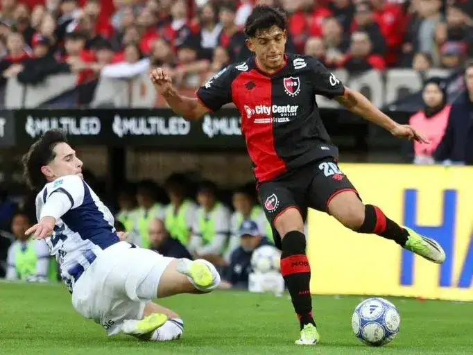 Facundo Guch avanza ante la marca de Santiago Fernández, en Newell's-Talleres.