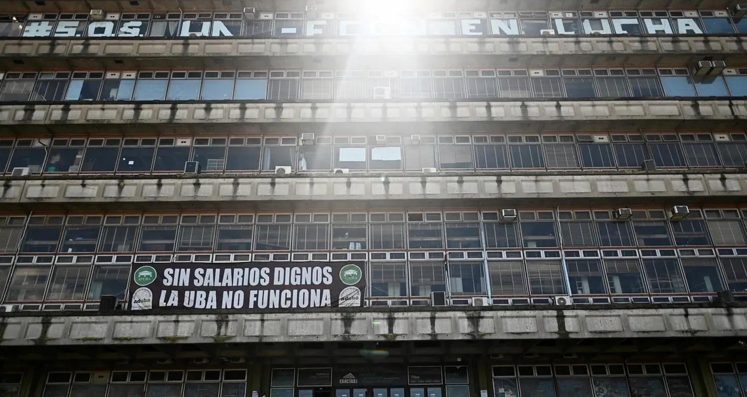 Un cartel que dice "La Universidad de Buenos Aires (UBA) no funciona sin salarios dignos" cuelga en el frontis de la Facultad de Ciencias Exactas en reclamo al recorte presupuestario del gobierno de Javier Milei. Foto: REUTERS / Pedro Lazaro Fernandez.