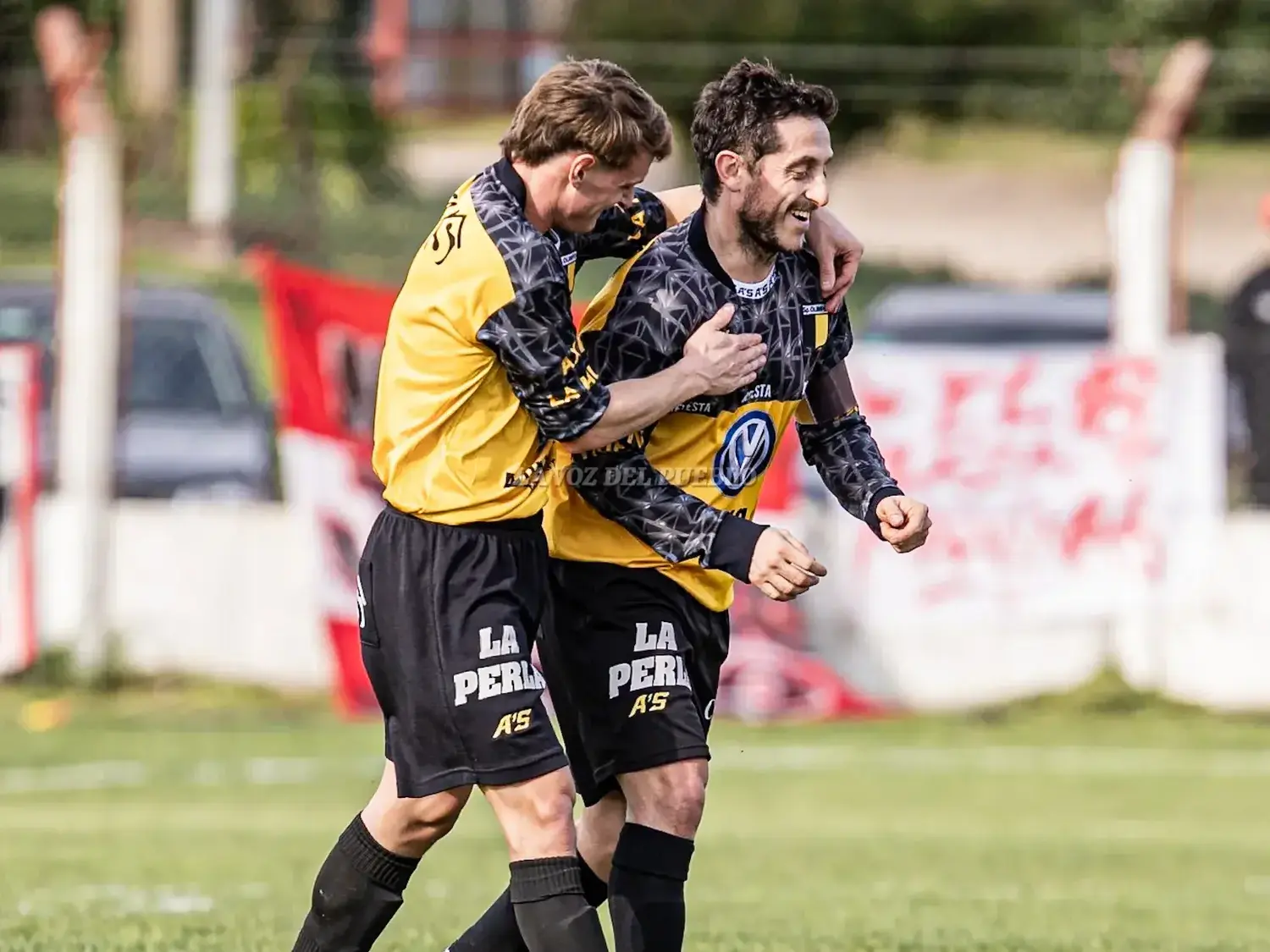Cristian "Cuchu" San Martín festaja con los puños cerrados el gol que abrió la cuenta contra Quilmes, mientras es abrazado por Juan Santa Cruz