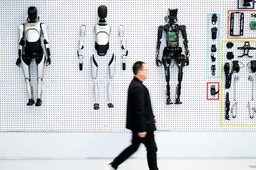 Un visitante camina frente a robots y componentes exhibidos en un centro de innovación de robots humanoides en la Zona de Desarrollo de Alta Tecnología del Lago Este de Wuhan, principal competidor de Estados Unidos en el terreno de los robots humanoides (Xinhua/Xiao Yijiu)