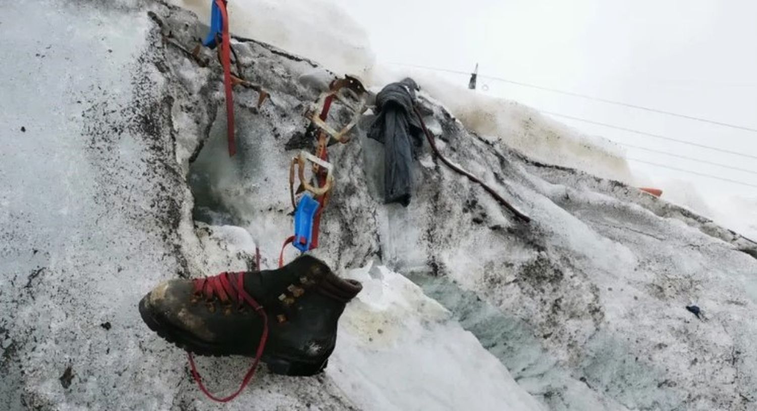 Las autoridades publicaron una fotografía de una bota de montaña con cordones rojos que sobresalía de la nieve, junto con algunos equipos de senderismo que habían pertenecido a la persona desaparecida. Foto: Valais Cantonal Police