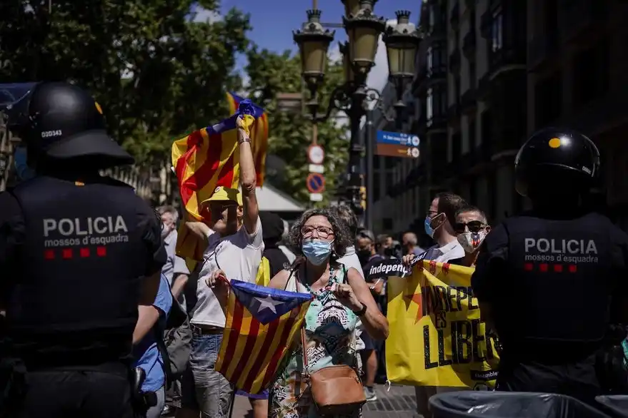 Manifestantes agitan banderas independentistas catalanas, durante un discurso del jefe de gobierno español Pedro Sánchez.