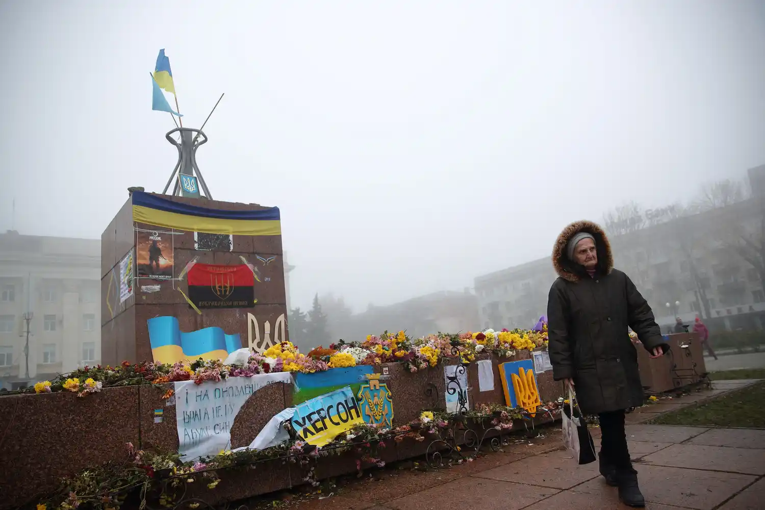 Una mujer pasa junto a una estatua en la plaza central después de la retirada militar rusa de Kherson.
