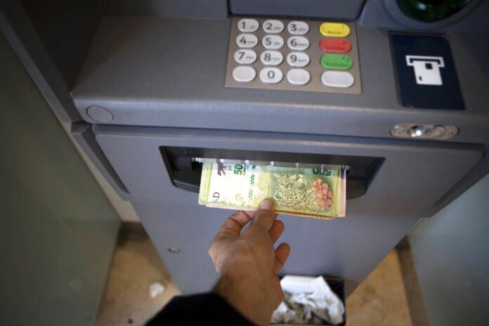 Una persona retira dinero de un cajero automático.