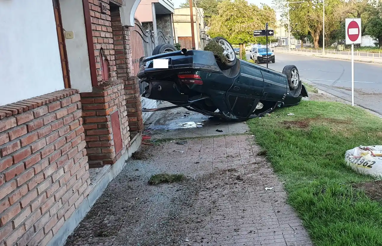 El auto chocó un árbol y terminó volcado en la vereda