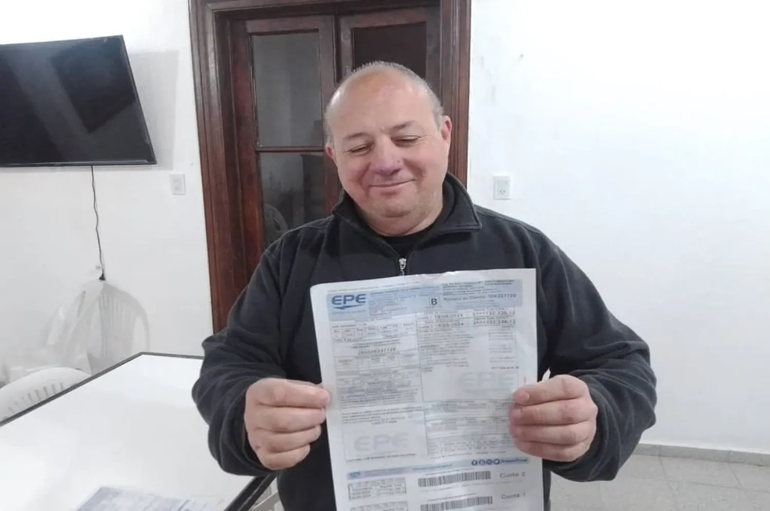 El padre Sergio Capoccetti sostiene la boleta más cara del servicio de energía eléctrica. Foto: Gentileza.