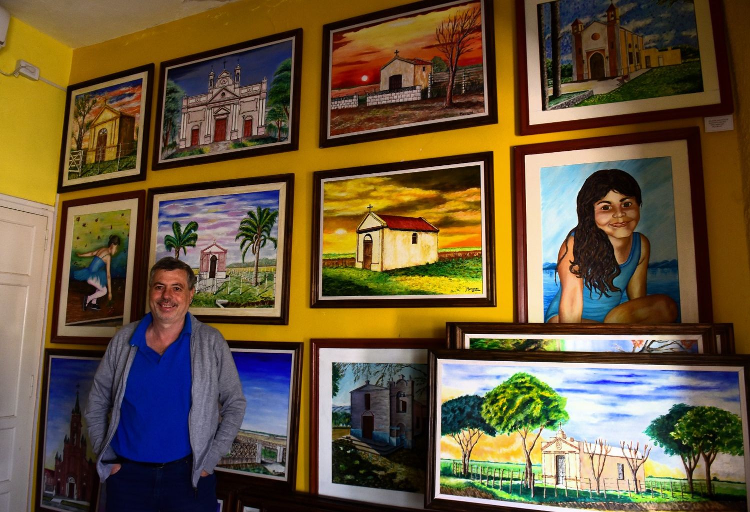 Carlos Monzoni junto a sus pinturas de 34 capillas rurales.