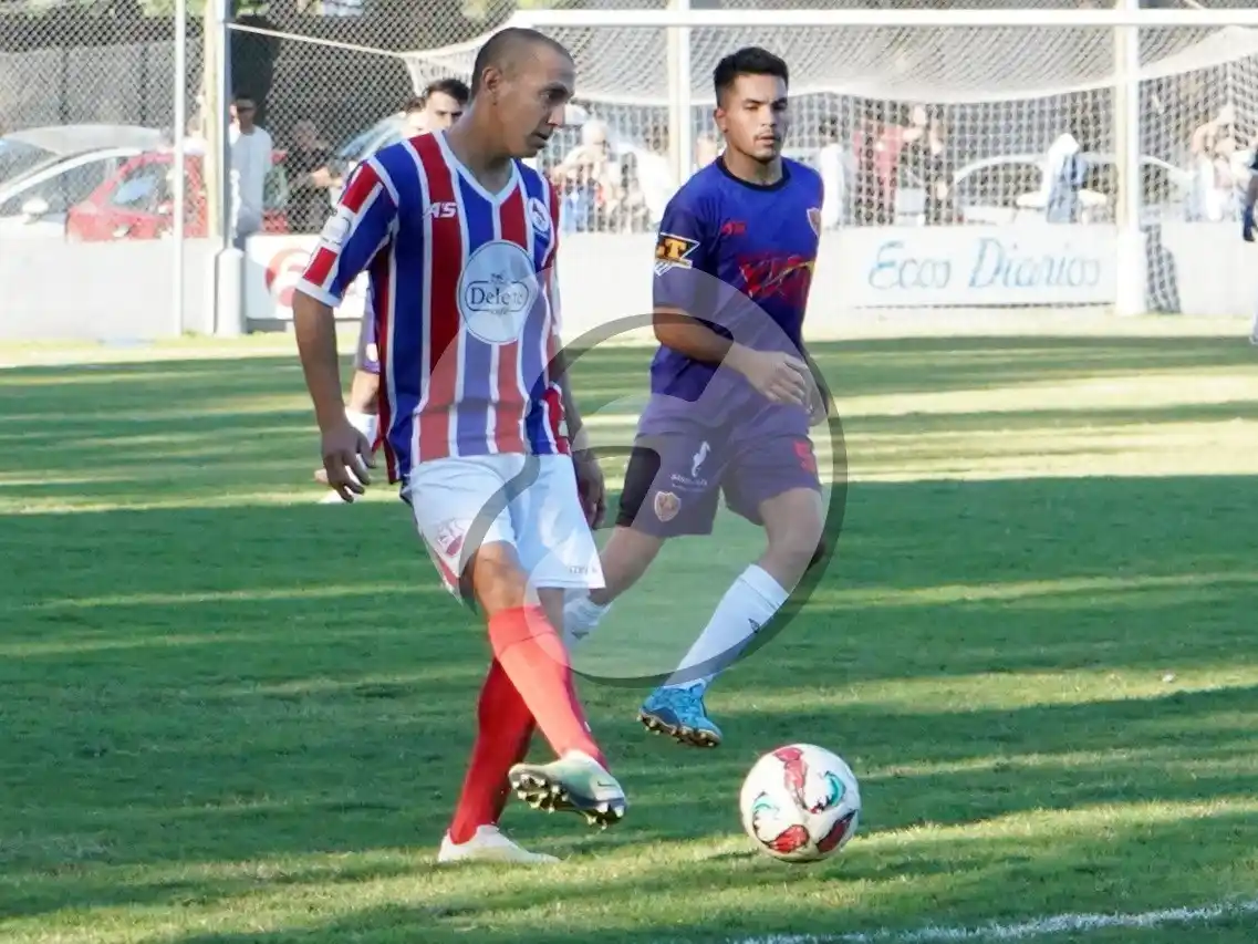 Nahuel Roselli cede la pelota ante la mirada de Gonzalo Martínez