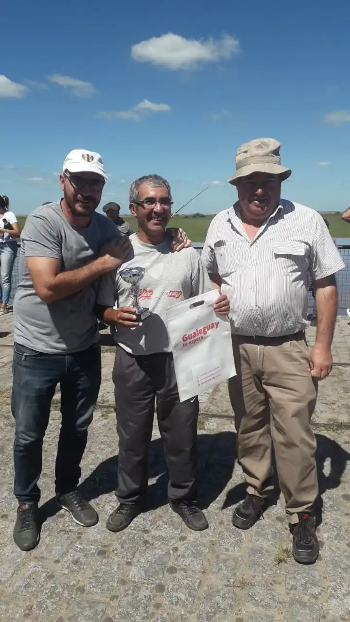 Mario Muñoz se adjudicó el torneo de pesca en Puerto Ruiz. En la gráfica vemos cuando recibe el premio mayor de manos del Secretario de Turismo, Cultura y Deportes de la Municipalidad, Ricardo “Tito” Lupi y del presidente del Martín Pescador, Javier Sciutto.