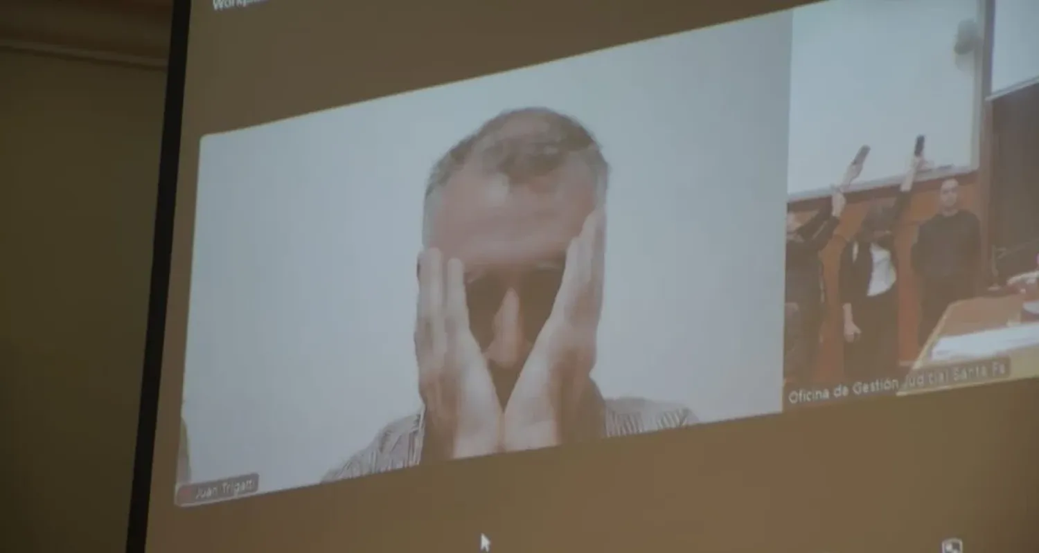 Juan Trigatti se lleva las manos al rostro al escuchar su absolución, en la audiencia final del juicio de la que participó por Zoom. Foto: Luis Cetraro