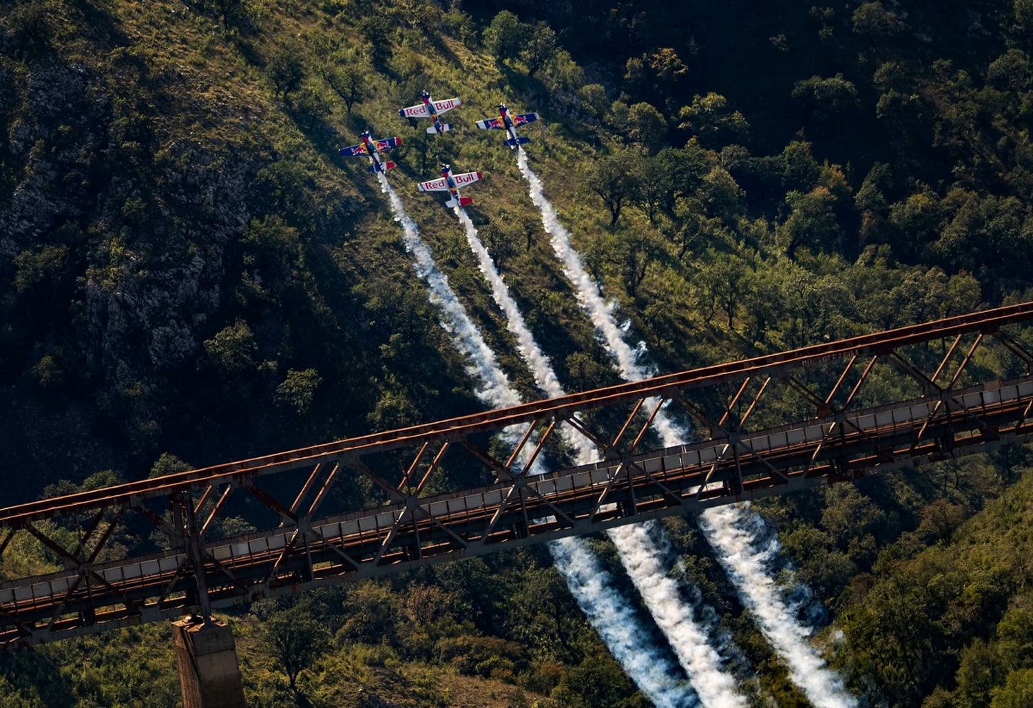 A 400 km/h, cuatro aviones de Red Bull realizan un loop invertido y pasan debajo de un puente ferroviario: video