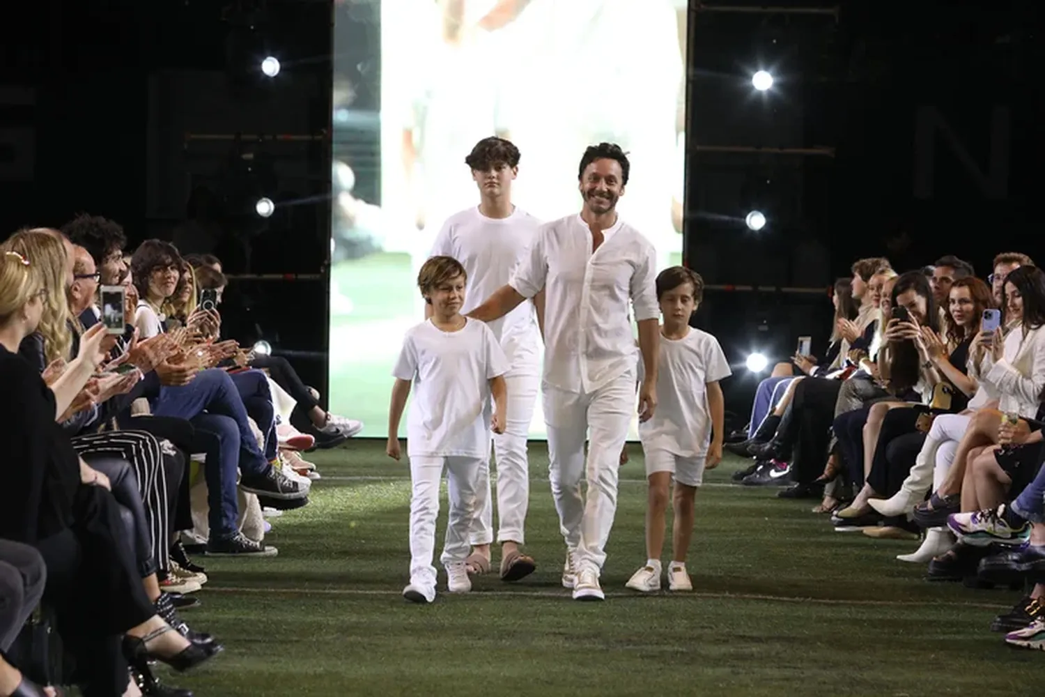 El actor y sus hijos caminaron por el campo de juego devenido en pasarela