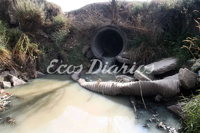 Un caño pluvial a cielo abierto y desechos que contaminan el río