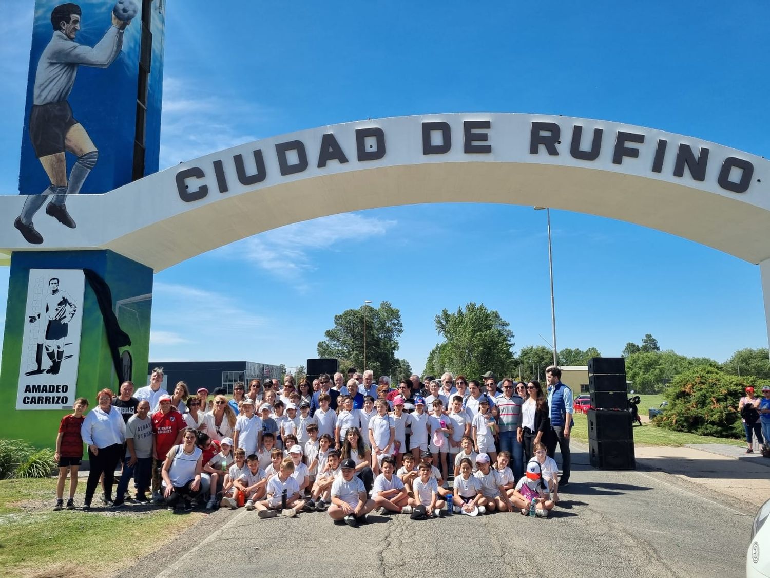 Foto final con familiares, amigos, autoridades y vecinos, en el Arco de Ingreso a la ciudad. Foto: Sur24