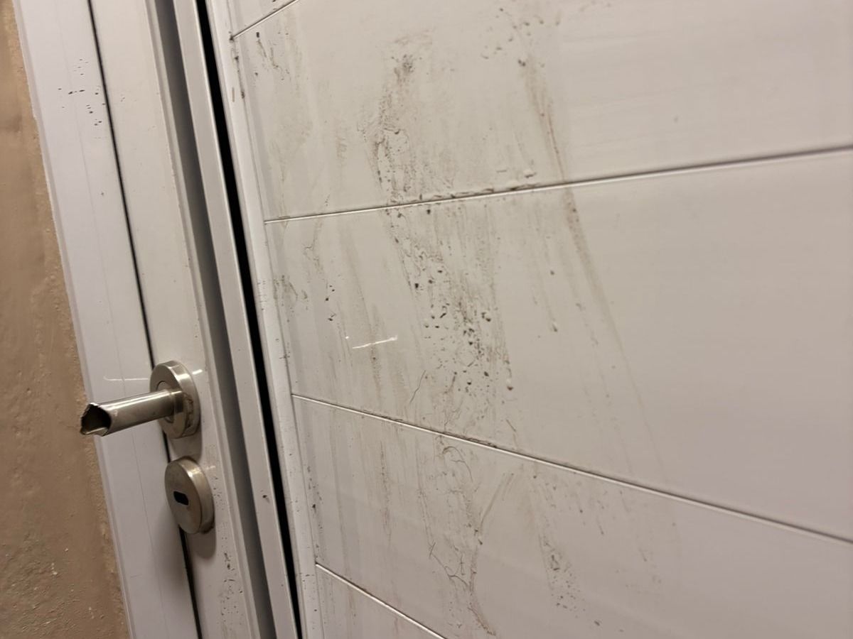 La puerta dañada por el hombre detenido.