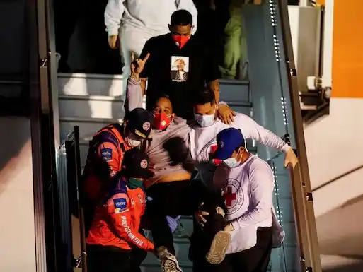 Un migrante venezolano es ayudado a descender del avión tras arribar a Caracas.