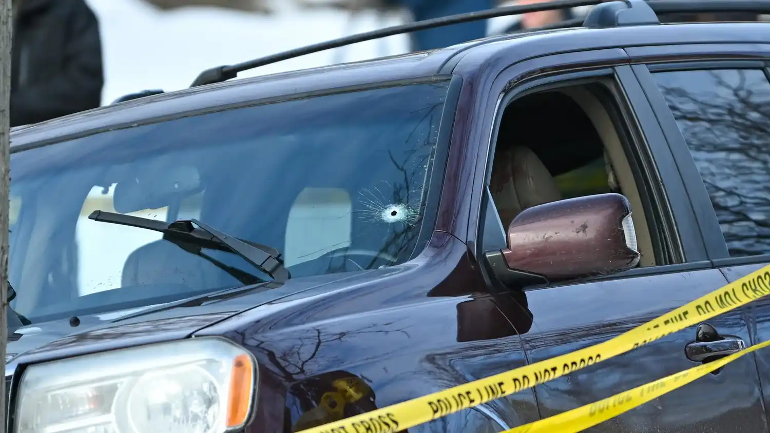 Se ve una cinta policial alrededor de un vehículo con un agujero de bala en el parabrisas después de que un conductor recibió un disparo en Minneapolis, Minnesota, EEUU