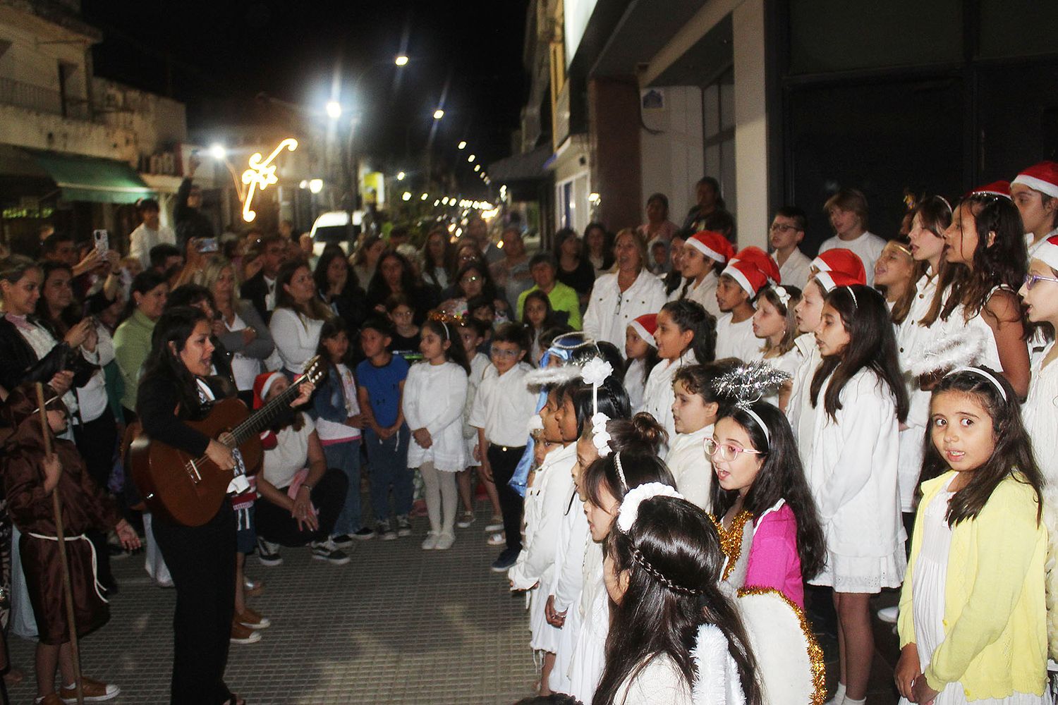 La profesora Yamila Valdez junto al coro de niños que dirige en la EMMIM.