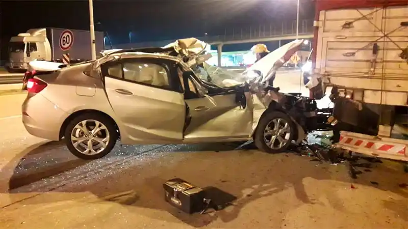 Un conductor terminó incrustado en su auto debajo del acoplado de un camión