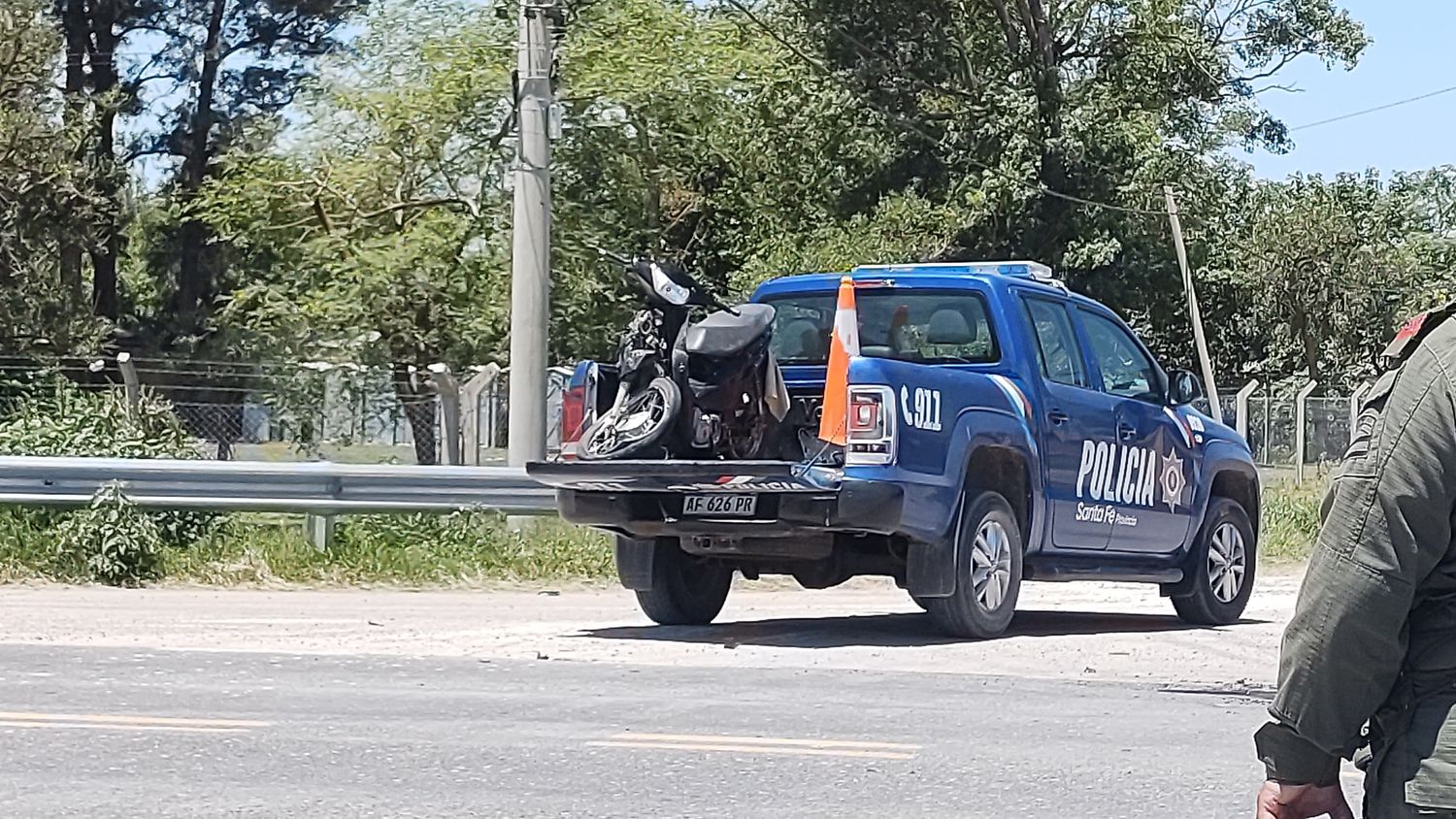 La motocicleta, destrozada tras el impacto, es trasladada por las autoridades.