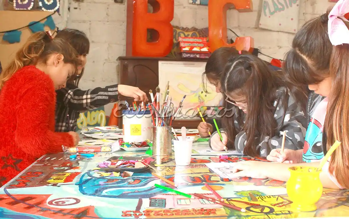 Pintando. Niñas y niños realizaban un taller de pintura con lápices y témperas
