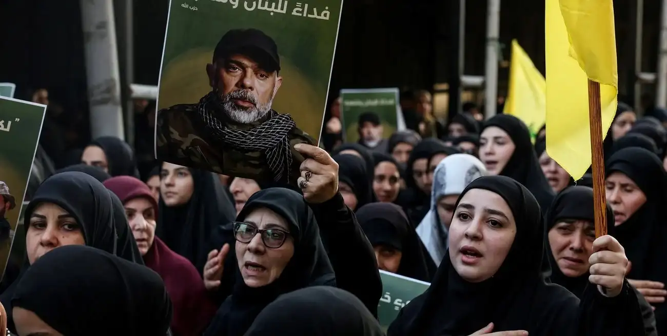 Una mujer sostiene una foto del principal oficial militar de Hezbolá, Haytham Ali Tabtabai, durante el funeral por él y otras personas que murieron en un ataque aéreo israelí el domingo, a pesar de una tregua negociada por Estados Unidos hace un año, en los suburbios del sur de Beirut, Líbano, el 24 de noviembre de 2025. REUTERS/Mohamed Azakir.