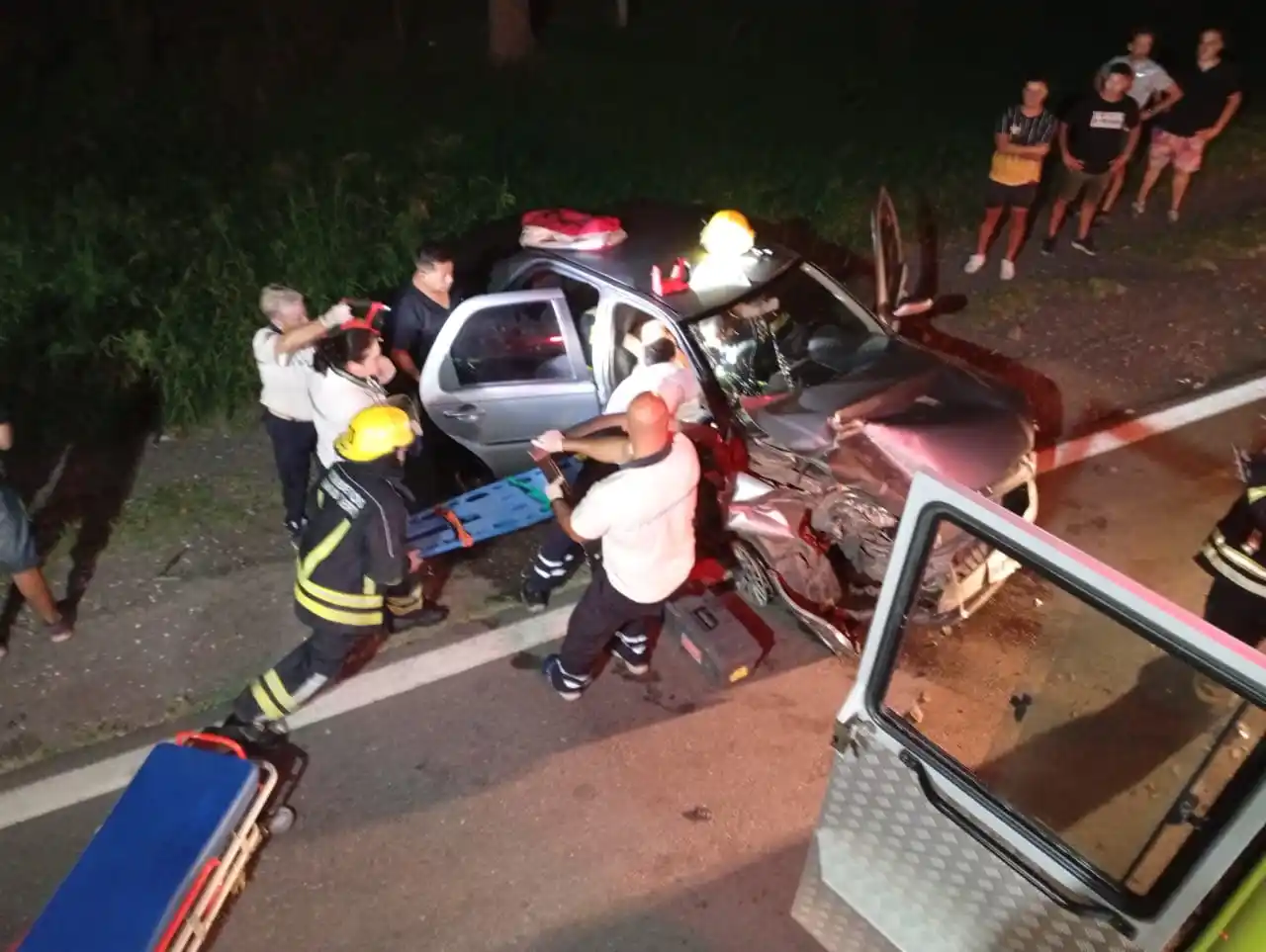 Personal de bomberos rescata a la mujer atrapada en el vehículo.