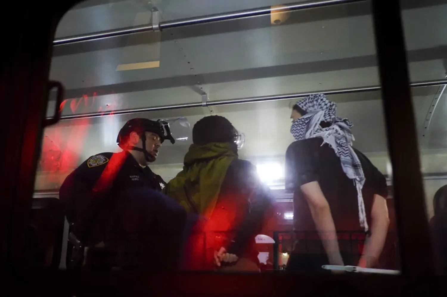 New York Police Department officers load arrested protesters from Columbia University onto a bus, on Tuesday in New York.