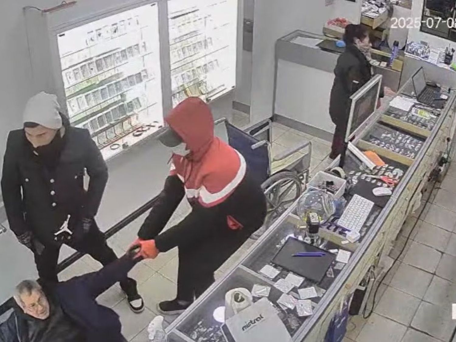 Momento en que los criminales arrastran a un cliente del local (Foto: captura video Mediodía Noticias)