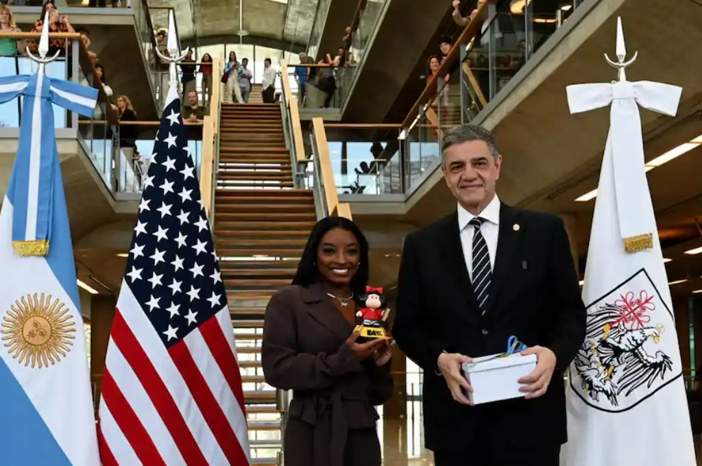 Simone Biles posa junto al jefe de Gobierno porteño, Jorge Macri, y la Mafalda en miniatura que le obsequiaron durante su visita a la Casa de Gobierno de CABA.