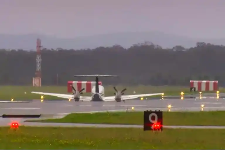 En esta imagen tomada de un video de la emisora Australian Broadcasting Corp., una avioneta desciendo sin el tren de aterrizaje en el Aeropuerto de Newcastle, Australia.