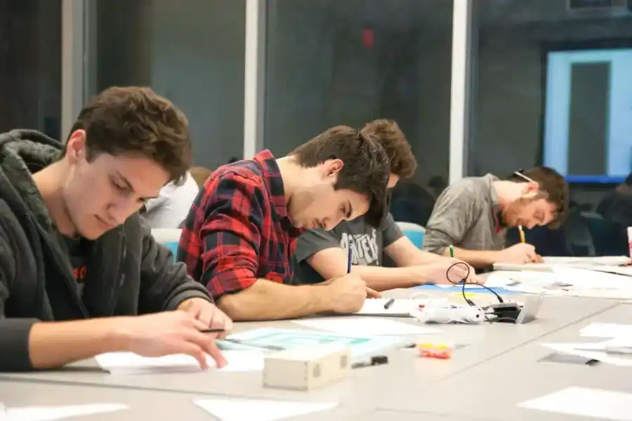 Una profesora y una pequeña ayuda a sus alumnos en un parcial 