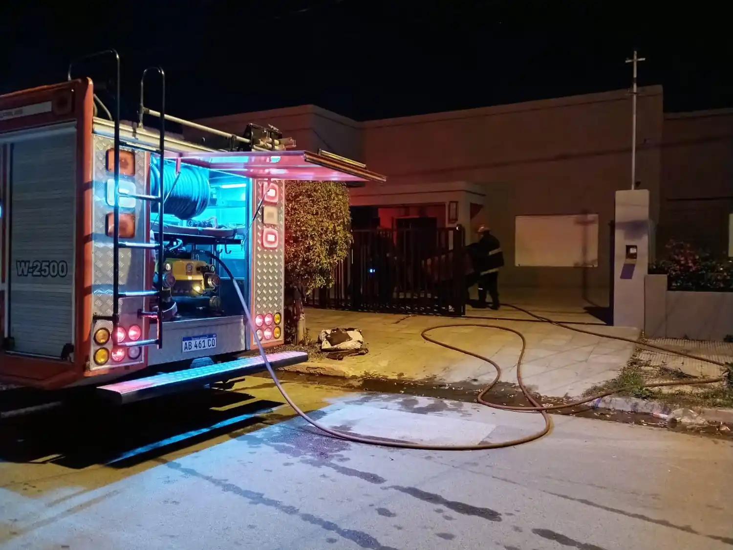 Bomberos retirando un sillón afectado por las llamas