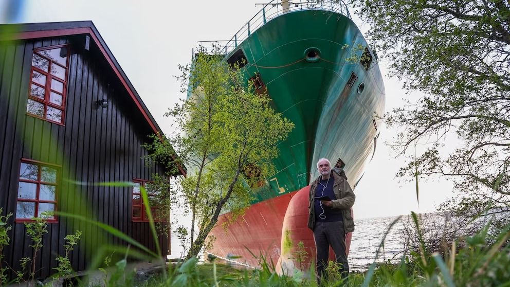 Johan Helberg se ve junto a su casa, con el buque portacontenedores NCL Salten al fondo, después de que el carguero de 135 metros se quedara encallado en Trondheimsfjord, a las afueras de Byneset, en Trondheim, Noruega el jueves 22 de mayo de 2025. (Jan Langhaug/NTB Scanpix via AP)