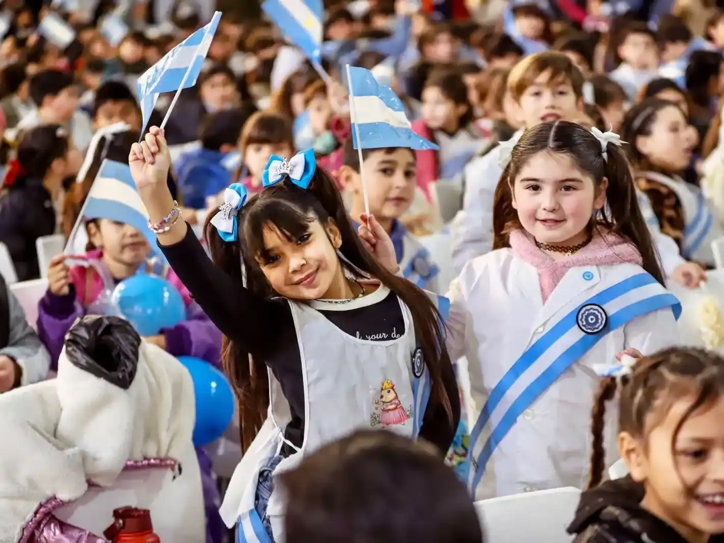 alumnos sostienen banderas argentinas en el acto de promesa de lealtad en pilar