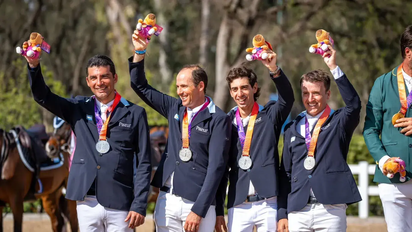 A la derecha de la imagen, Tomás Galilea sonríe con "Capi" -el carpincho- en alto y la medalla de plata colgada (Foto: Instagram Federación Ecuestre Argentina)